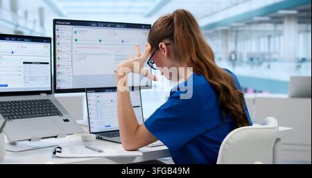 Healthcare Manager Looks Tired While Checking Billing Data On Laptop Screen. Stock Photo