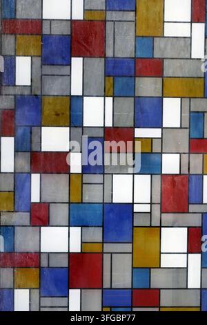 Geometric grid pattern featuring various sized rectangular shapes in primary colors red, blue, yellow, and white, with gray, creating an abstract, art Stock Photo