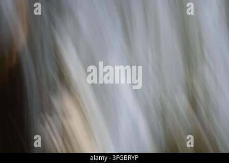 abstract closeup of softly blurred pale wooden grain, blending cool gray, blue, beige, and warm brown tones with subtle knots, vertical streaks, gentl Stock Photo
