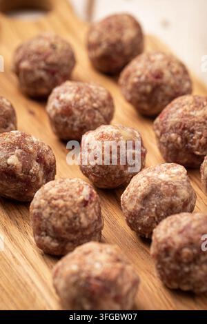 Raw meat meatballs on wooden cutting board Stock Photo