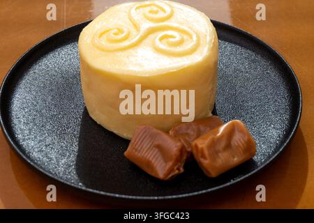 Creamy golden French handmade on farm butter from Brittany and caramel candies with sea salt flavor. Premium artisanal dairy product of Brittany. Stock Photo