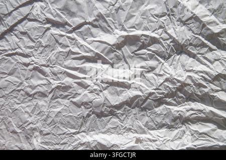 White crumpled wrinkled paper texture background, abstract rough paper surface with folds and shadows for design Stock Photo