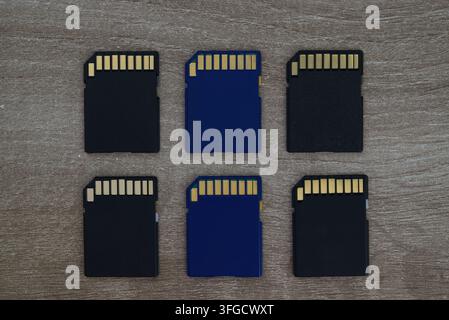 Top-down flat lay view of multiple micro SD memory cards arranged in a neat grid pattern on a light wooden background. Stock Photo