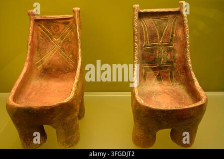 BOGOTA, COLOMBIA - NOVEMBER 11 2025: Two terracotta ceremonial chairs with geometric painted decorations displayed at the Gold Museum in Bogota, Colom Stock Photo