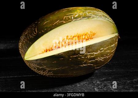 sliced christmas melon on black wood background Stock Photo