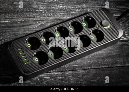 power filter extension cord on black wood background Stock Photo