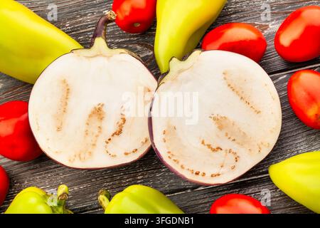 sliced round purple eggplant on wood background Stock Photo
