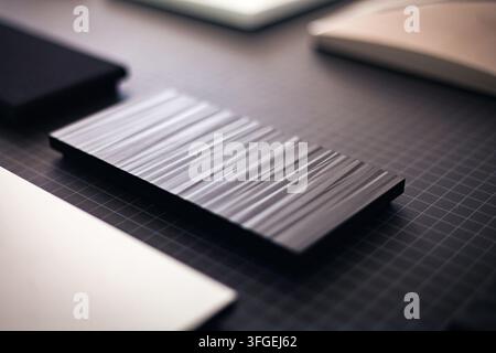 Close-up shot of an artisanal textured black ribbed block specimen arranged on a grid cutting mat in a studio workspace, Portugal Stock Photo