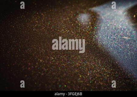 Close-up macro abstract view of a dark metallic car paint finish with sparkling multi-colored glitter flakes reflecting light, Portugal Stock Photo