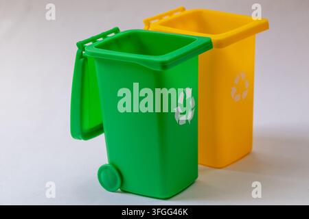 Two plastic recycling bins stand isolated on a white studio background. Stock Photo