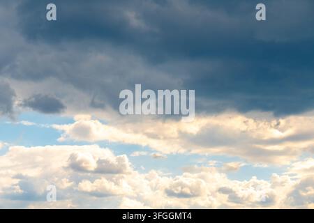 Dramatic clouds fill the sky with soft sunlight and a blue opening. Stock Photo
