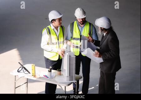Real estate developer directs and plans during project meetings with engineers, High angle view senior site managers with corporate engineering team d Stock Photo