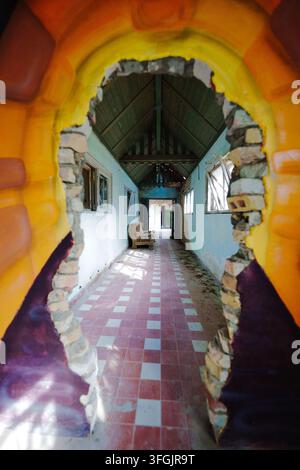 View through broken wall into corridor of abandoned Heilstätte Grabowsee, Germany. Urbex lost place art decay. Stock Photo