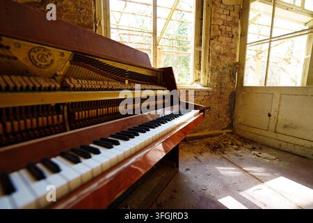 Close-up of an old broken piano in an abandoned room at Heilstätte Grabowsee, Germany. Urbex lost place decay interior. Stock Photo