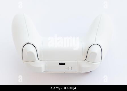 A white wireless game controller is shown from the back view Stock Photo