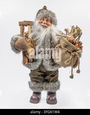 Traditional Nikolaus doll with fur clothing, sack and rustic accessories, isolated on white background, German Christmas decoration. Stock Photo