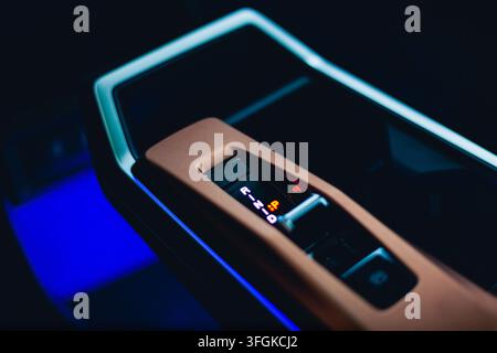 Macro detail of the electronic gear selector and blue ambient lighting inside a modern car interior. Stock Photo