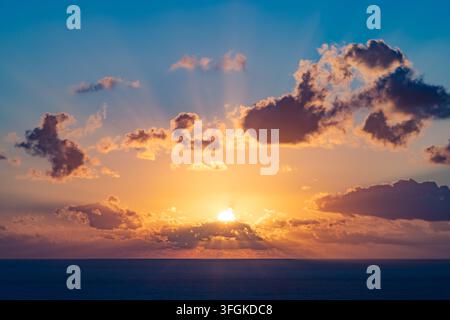 Sky with the sunrise breaking through the clouds and its distinct rays Stock Photo