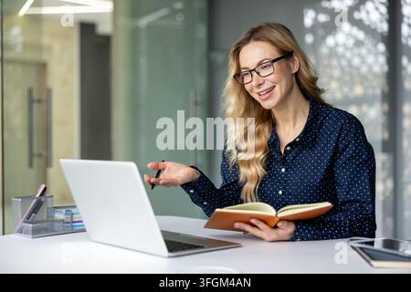 Remote work and video conferencing, professional woman having an online meeting on laptop in modern office. Stock Photo