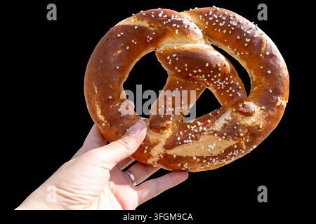Pretzel in Hand. Bakery street food isolated on background Stock Photo