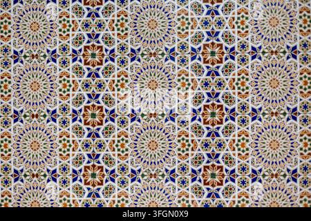 Ornate Geometric Ceramic Tile Pattern in Blue and Green. Colorful ceramic tiles form an intricate repeating geometric pattern with floral rosettes in Stock Photo