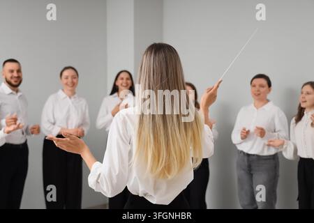 Leadership and team collaboration, conductor leading a diverse group of professionals in a corporate training session or creative workshop Stock Photo