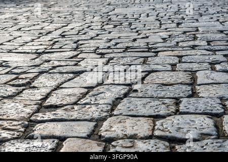 Old stone pavement texture with weathered cobblestone surface background. Rustic texture, abstract background, aged material, urban paving, historic Stock Photo