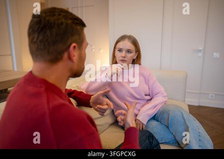 Concentrated woman psychotherapist attentively listening to man client on consultation session. Stock Photo