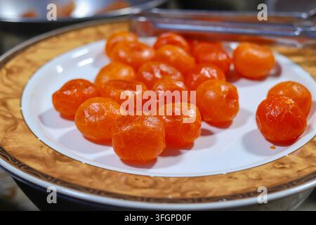A close-up of cooked salted egg yolks on a white melamine plate with a wood-grain rim, photographed in Bangkok, Thailand. Stock Photo