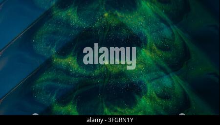 Sparkling splash. Defocused glitter ink. Green blue purple color glimmer art texture shiny fluid spilling on abstract background. Stock Photo