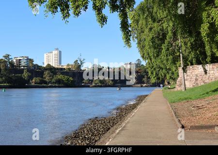 A view of the Brisbane River and Kangaroo Point Cliffs from a riverside pathway in the Brisbane City Botanic Gardens in Queensland, Australia Stock Photo