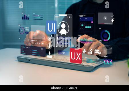 Person interacts with floating digital UI UX design tools above laptop. Hands hover over holographic interface elements like charts, icons, and user p Stock Photo