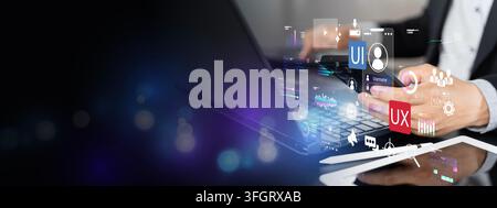 Hand interacts with glowing digital interface over laptop. Icons show UI and UX design concepts. Professional user focuses intently on creative projec Stock Photo