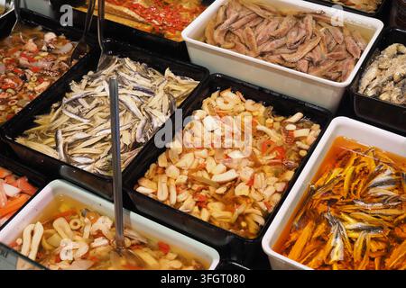 Various seafood dishes displayed in containers at a market Stock Photo