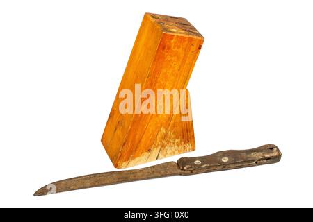 An old wooden knife stand. In the foreground is an old rusty knife. Antique kitchen utensils on a white background. Stock Photo