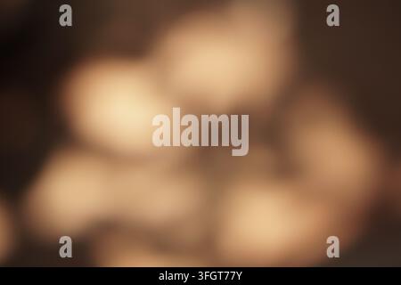 An abstract, soft-focus background featuring warm light brown tones and blurred circular bokeh lights, creating a gentle and inviting ambiance. Ideal Stock Photo