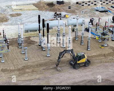 Aerial view of electrical substation equipment during construction, with high voltage switchgear, transformer components and earthworks visible across Stock Photo