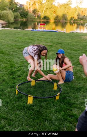 Two young women laughing playing roundnet game on grass Stock Photo