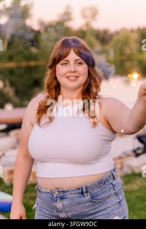 Happy young woman holds a sparkler outdoors Stock Photo