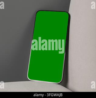Smartphone mockup with green screen on a minimalist abstract background. Angled mobile phone leans against a light and dark surface. Ideal for app adv Stock Photo