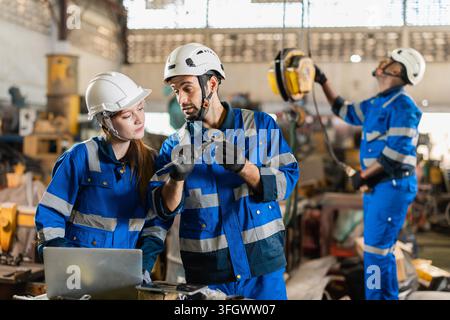 Factory Technicians Male and Female Talking Discussion Working together in Dirty Grunge Heavy Equipment Warehouse. Stock Photo