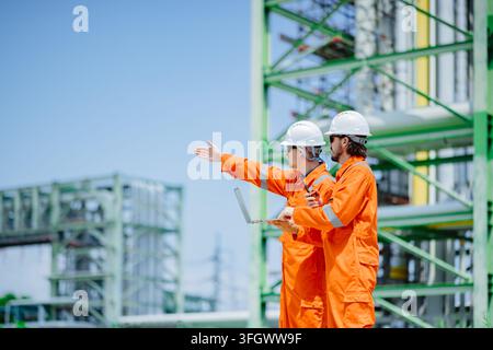 Refinery Engineers Discussion Pointing Direction Outdoor Chemical Plant Inspection Two Engineers Holding Laptop Communication Site Visit Operation Pet Stock Photo