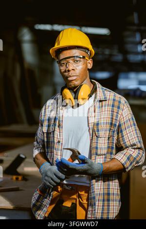 Portrait African Black Male Carpenter Worker Wearing Yellow Safety Helmet Standing Inside Wood Furniture Manufacturing Factory Workshop Site Stock Photo