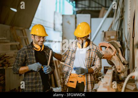 Two Male Carpenters Standing Together Discussing Work Plan Near Machinery Inside Wood Furniture Manufacturing Workshop Plant Stock Photo