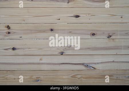 Natural wood privacy fence surface with stacked horizontal boards, strong woodgrain patterns showing unfinished lumber texture Stock Photo