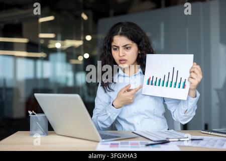 Businesswoman Presenting Financial Analysis And Data Charts On Laptop In Corporate Office. Professional Manager Analyzing Documents And Working At Desk With Computer. Stock Photo