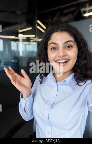 Confident Businesswoman Having A Video Call In A Corporate Office, Professional Employee Communicating With Colleagues During A Virtual Meeting. The Indian Businesswoman Is Working At Her Desk Using. Stock Photo