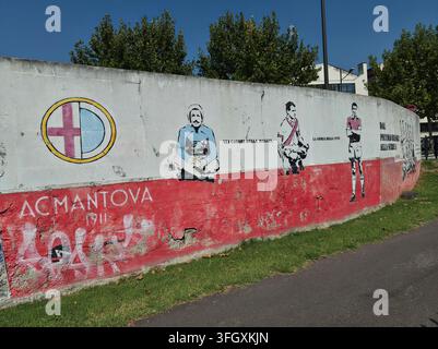 outdoor wall mural featuring the AC Mantova 1911 football club crest and historic player portraits in the city of Mantua, Italy. Stock Photo