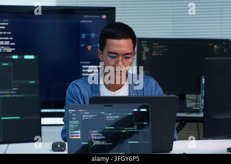 Focused programmer working on software development, writing code and exploring digital technology, cybersecurity and artificial intelligence applicati Stock Photo