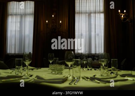 Place setting on greenly lit by stained glass table in Sociëteit de Vereeniging in The Hague, Netherlands Stock Photo